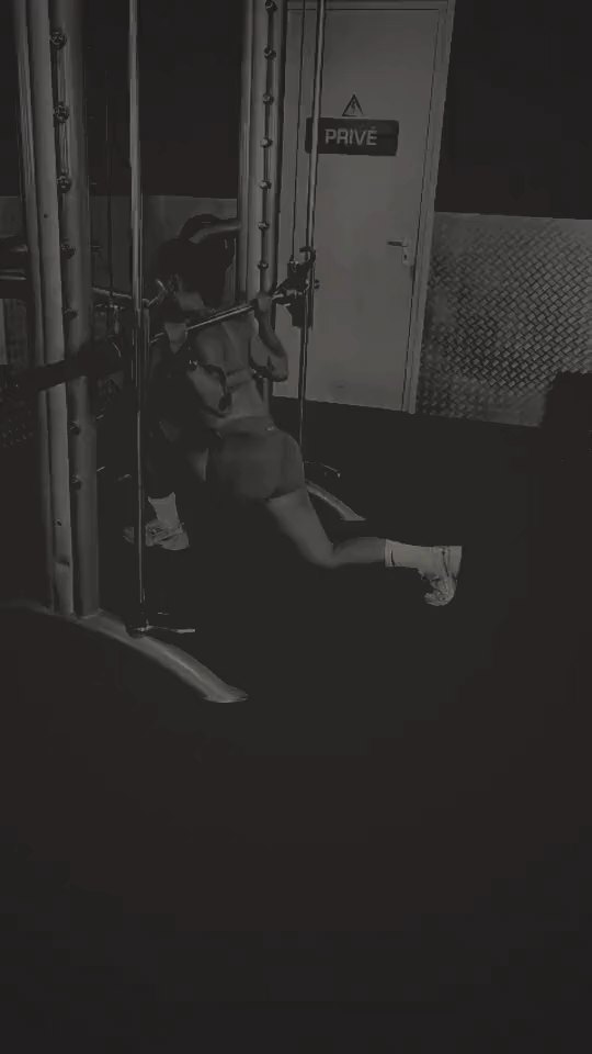 Client training on the cable machine, black-and-white