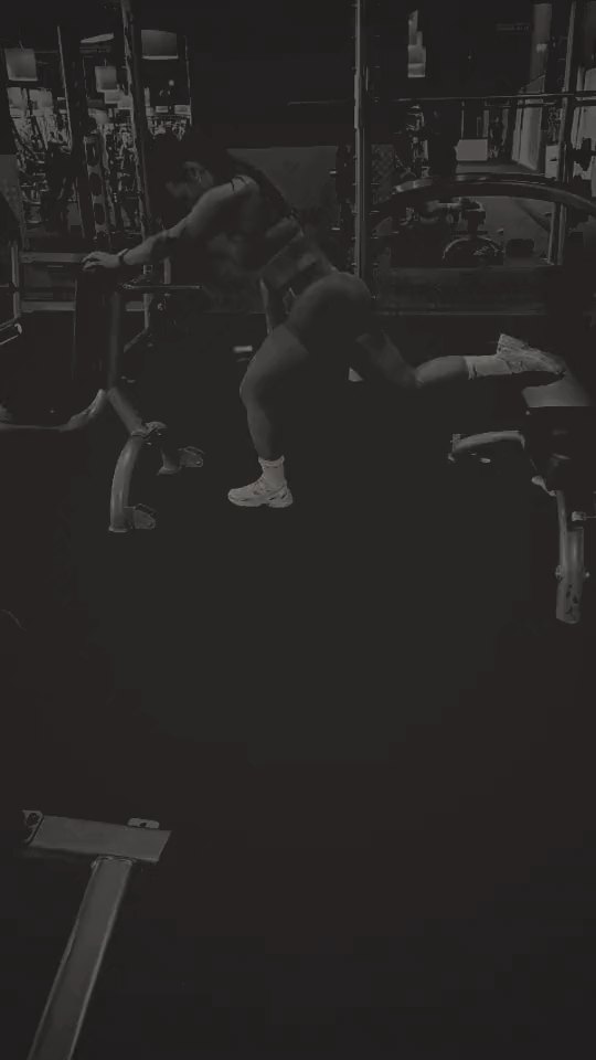 Client performing walking lunges in the gym, black-and-white
